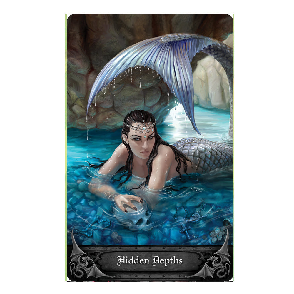 Anne Stokes Gothic Oracle Card - Hidden Depths. A beautiful mermaid relaxes in blue water with her tail up over her head. Her hand clutching a skull beneath the water.