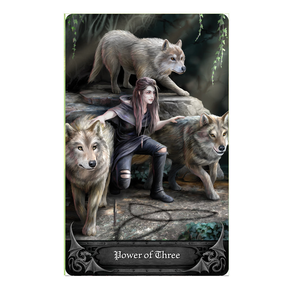 Anne Stokes Gothic Oracle Deck card - Power of Three. A huntress of the woods in tattered pants and a hooded jacket is flanked by 3 friendly gray wolves.