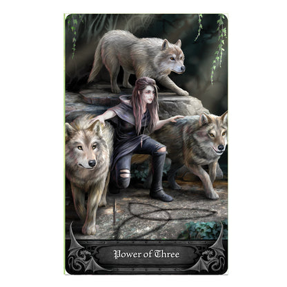 Anne Stokes Gothic Oracle Deck card - Power of Three. A huntress of the woods in tattered pants and a hooded jacket is flanked by 3 friendly gray wolves.
