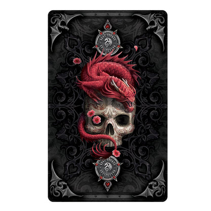 Back of card detail for Anne Stokes Gothic Oracle Deck cards. A gothic black background featuring hearts within clubs with four silver dragons adorning the card edges. The center is filled with a tattooed skull, its right eye covered with a red flower and atop the skull is a red dragon. Emblems top and bottom are the Anne Stokes Collection.
