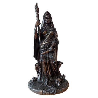 Statue of Hecate holding a torch and a dagger flanked by black dogs and standing close to a skull.
