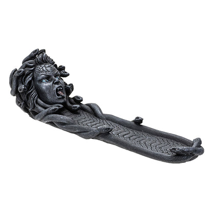 Dark grey resin cast Medusa incense burner with her at one end of the burner.