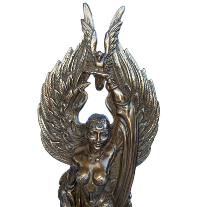 Detail photo of a statue of The Morrigan including her wings holding up a crow on her left hand