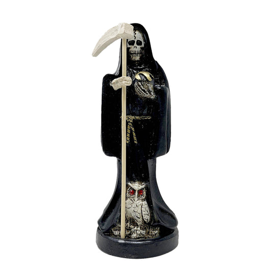 Decorative figurine of a Santa Muerte skeleton holding a scythe with an owl at her feet on a white background